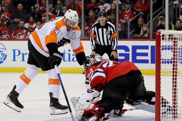Flyers center Sean Couturier slips the puck past New Jersey goaltender Mackenzie Blackwood in the shootout Friday night at the Prudential Center in Newark, N.J. The Flyers beat the Devils in the shootout, 4-3.