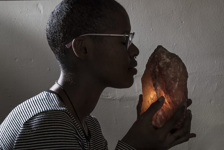 Kimani Keaton, of West Philadelphia, holds a pink Halite soft crystal that has an inner light illuminating it. She uses it to clean the air in her apartment. It also is associated with self love, emotional cleansing, and inner clarity.