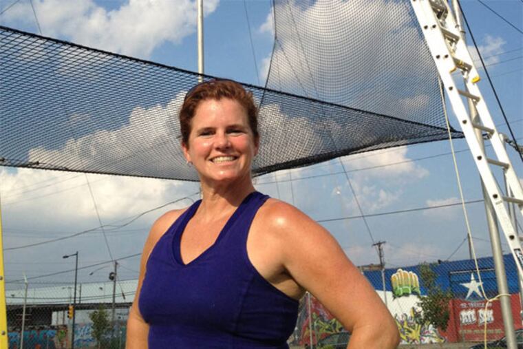 Mary Kelly Rayel, a flying trapeze instructor, in front of her trapeze rigging in North Philadelphia. (Michael Hinkelman / Staff)