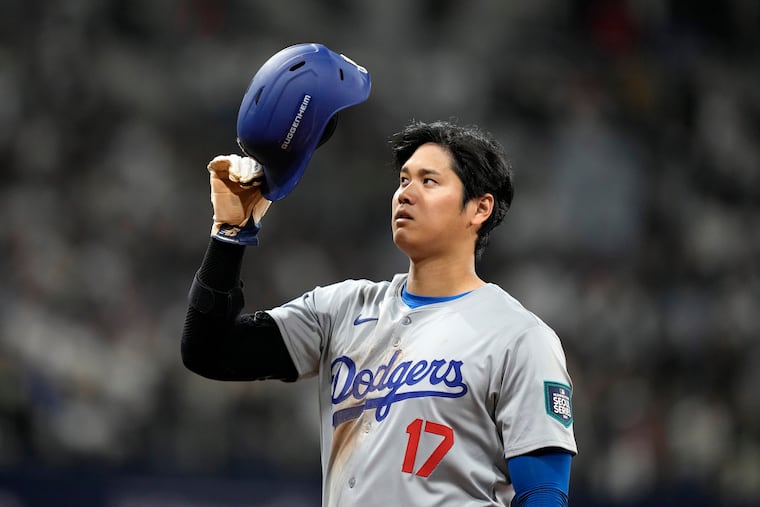 Dodgers designated hitter Shohei Ohtani takes his helmet off after hitting an RBI single against the Padres on Wednesday in Seoul, South Korea.