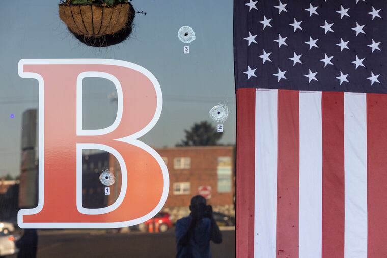 Bullet holes in the front windows of Philly Bar & Restaurant.