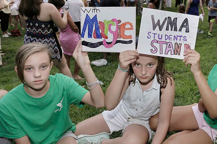 Waldron Mercy Academy students (from left) Katie Dewey, Christina Schwab and Moira Arechavala (partially hidden) show support for fired educator Margie Winters.