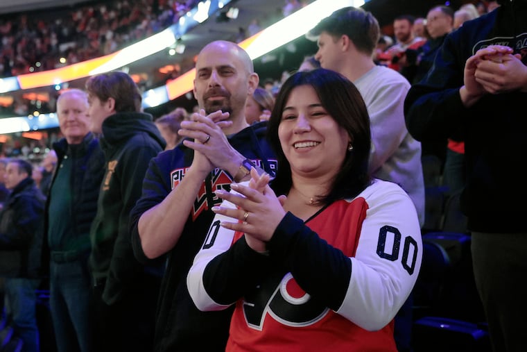 James, left, and Muriel Crescenzo applaud the National Anthem before Tuesday's Flyers-Capitals game.