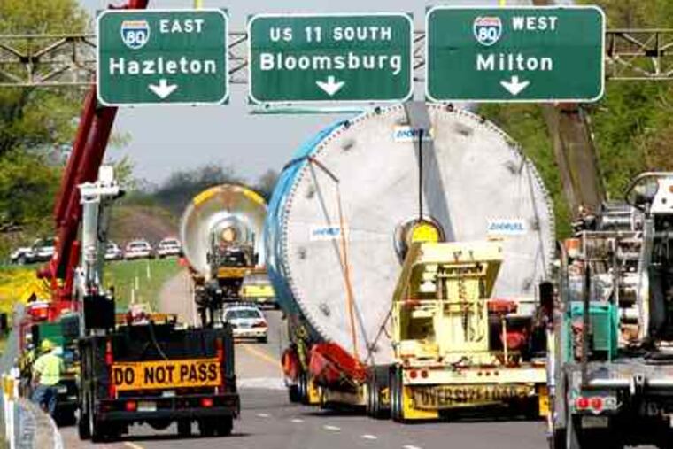 BILL HUGHES / Bloomsburg (Pa.) Press A hold-up on I-80: Signs are lifted to allow industrial gear to pass near Berwick, Pa. The Pa. Turnpike Commission wants to take the road over.