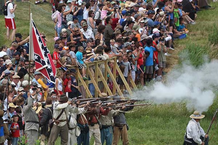 With hundreds of spectators looking on, reenactors from General Henry Heth's infantry fire into the Union infantry during a squirmish showing the first day of battle. First day of the battle of Gettysburg is represented bya squirmish between Union Genearl John Buford and Confederate General Henry Heth. 150th Gettysburg Anniversary national Civil War Battle Reenactment held at The Redding Farm in Gettysburg on Thursday, July 4, 2013. (MICHAEL BRYANT / Staff Photographer)