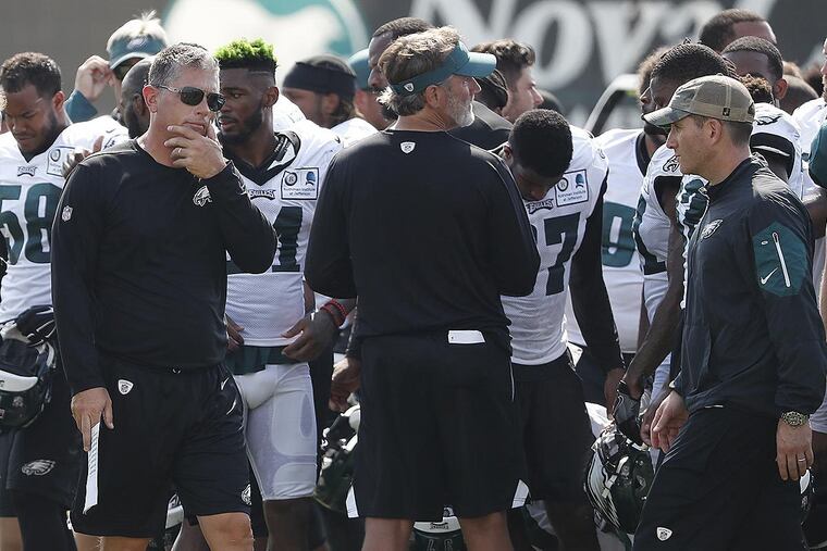 Defensive coordinator Jim Schwartz (left) pauses at the end of practice.