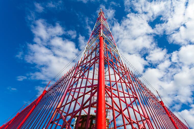 A telecommunication tower with panel antennas and radio antennas and satellite dishes for mobile communications. Telecom companies are seeking ways to rapidly deploy 5G technology but there are many critics.
