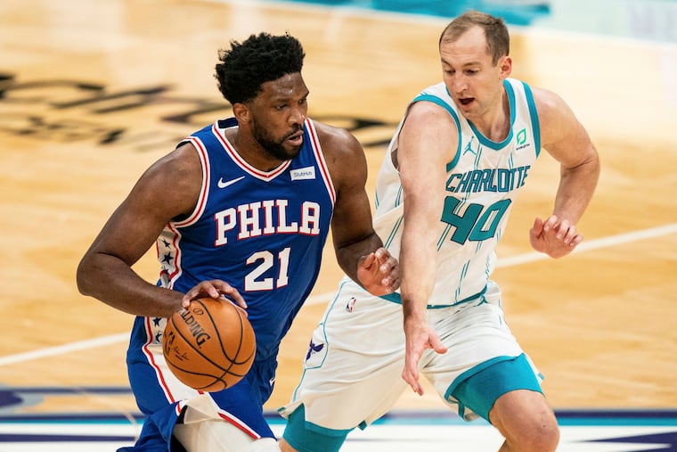 Joel Embiid (21) brings the ball up court while guarded by Charlotte Hornets center Cody Zeller (40) during the first half.