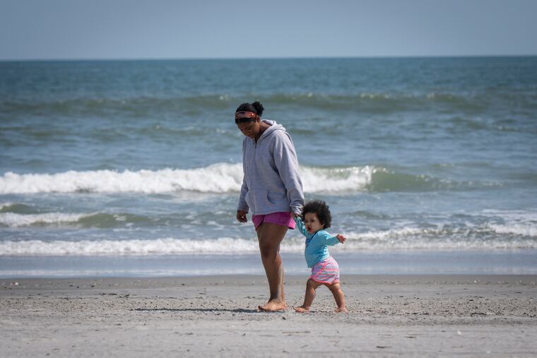 Jianna Cassell (left) walks on the beach with little sister Mariyah Spence in Atlantic City.
