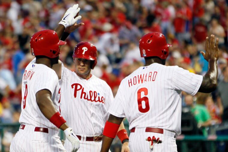 Domonic Brown (left) is congratulated on his three-run home run by Michael Young (center) as Ryan Howard, who scored, heads to the dugout during the first inning of a baseball game with the New York Mets, Wednesday, April 10, 2013, in Philadelphia. (Tom Mihalek/AP)
