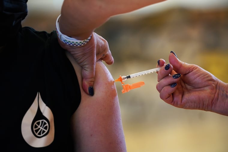 Nurse Kimball Dunlap gives a dose of the Pfizer COVID-19 vaccine to a patient at a vaccination clinic at Cheltenham High School in Wyncote, Pa., on May 19.
