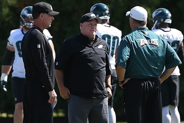 Eagles' offensive coordinator Pat Shurmur (left) head coach Chip Kelly (center) and defensive coordinator Bill Davis (right) talk. (David Maialetti/Staff Photographer)