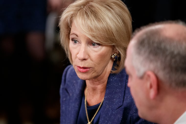 Education Secretary Betsy DeVos, talks with Louisiana Gov. John Bel Edwards before President Donald Trump arrives to speak at the 2019 White House Business Session with Our Nation's Governors in the White House on Feb. 25. Under DeVos, the Department of Education has relaxed regulations on student loan servicers.