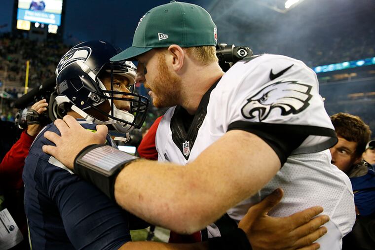 Carson Wentz (right) embraces Russell Wilson after their 2017 meeting in Seattle. Wilson is 4-0 against the Eagles, including two wins against Wentz.