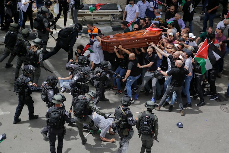 Israeli police confront with mourners as they carry the casket of slain Al Jazeera veteran journalist Shireen Abu Akleh during her funeral in east Jerusalem.