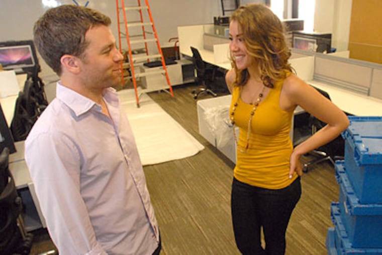 Account coordinator Kirsten Farkas chats with Dan Hughes, Director of Client Development, Friday as workmen put the finishing touches on Neiman's new headquarters at 1619 Walnut Street. (April Saul / Staff Photographer)