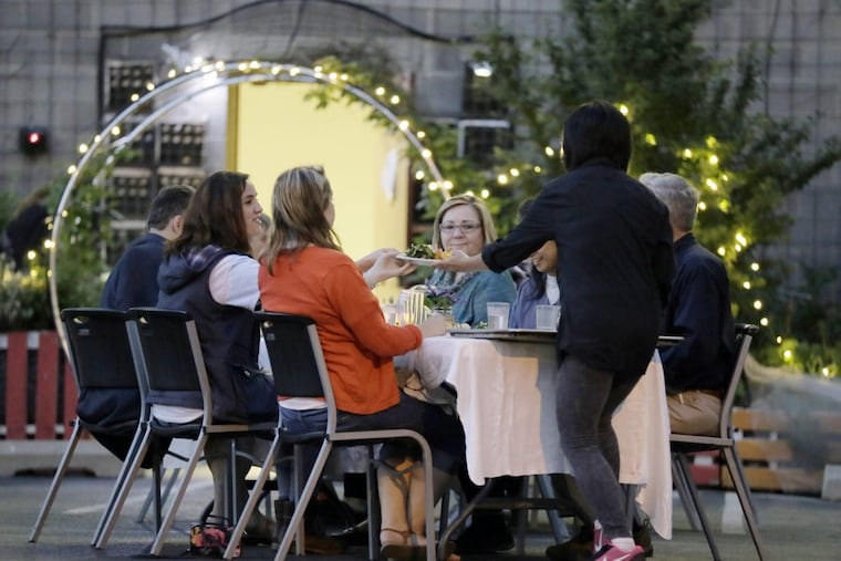 Meei Ling Ng serves a table during the fundraising dinner in the parking lot of the Sunday Breakfast Rescue Mission, ELIZABETH ROBERTSON / Staff Photographer )