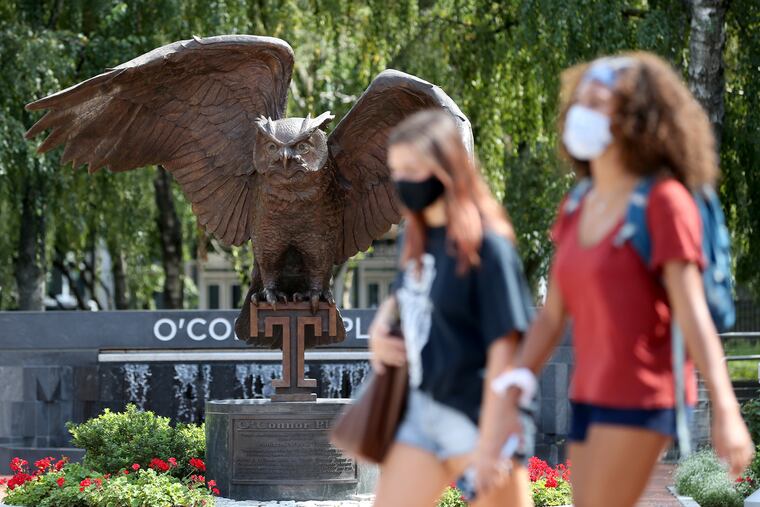 Students walk along Liacouras Walk at Temple University on Thursday. The university has now confirmed more than 300 students with the coronavirus.