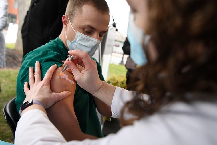 Colleen Teevan, System Pharmacy Clinical Manager at Hartford HealthCare, administers the Pfizer-BioNTech vaccine for COVID-19 to healthcare worker Connor Paleski outside of Hartford Hospital, Monday, Dec. 14, 2020, in Hartford, Conn.