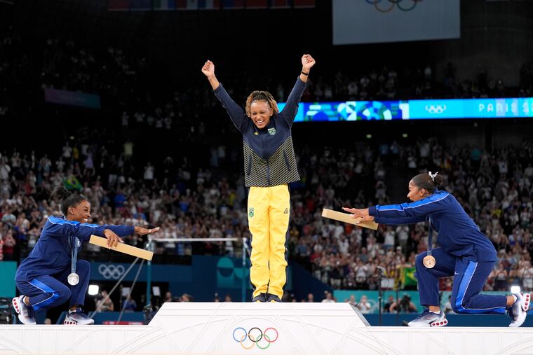 Silver medalist Simone Biles (left) and bronze medalist Jordan Chiles bow to gold medalist Rebeca Andrade, of Brazil, during a gymnastics medal ceremony Monday at the 2024 Summer Olympics in Paris.