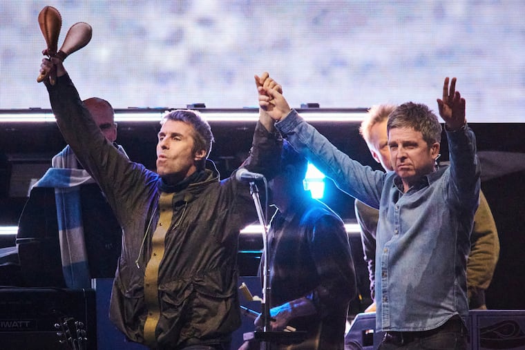 FILE - Liam Gallagher, left, and Noel Gallagher of Oasis walk onstage together during their reunion tour in Toronto, Sunday, Aug. 24, 2025. 'Oasis: Don't L;ook Back in Anger,' the new documentary about the band's 2025 reunion tour, is in Philly area theaters (Sammy Kogan/The Canadian Press via AP, File)