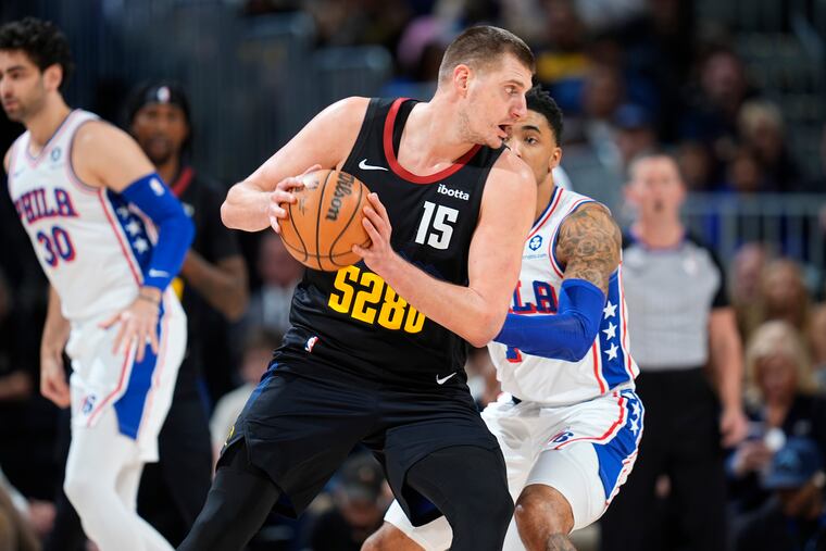 Denver Nuggets center Nikola Jokic, front, looks to pass the ball as Sixers forward KJ Martin defends on Jan. 27.