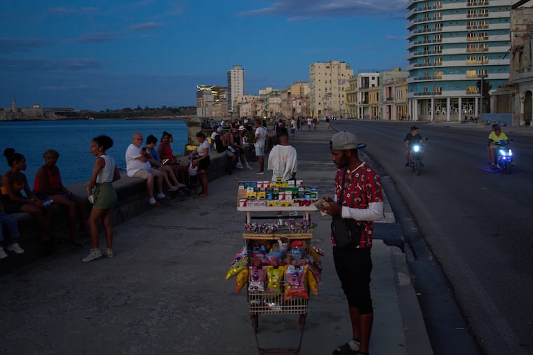 A street vendor waits for customers on the Malecón during a blackout in Havana, Monday, March 16, 2026. (AP Photo/Ramon Espinosa)