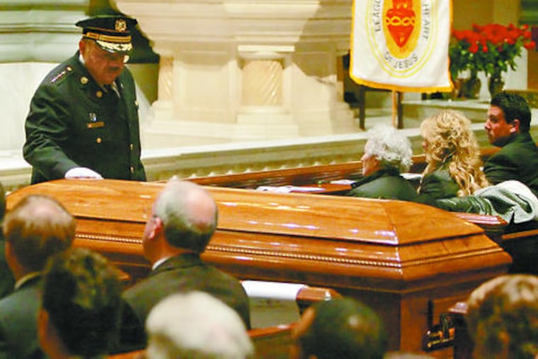 Police Commissioner Charles H. Ramsey gently touches Sgt. Timothy Simpson's coffin after speaking during the Funeral Mass. "Tim will forever be shrouded in glory and honor," Ramsey said in a message distributed at the service.