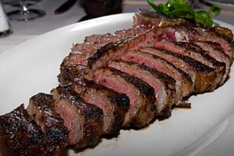 Craig LaBan says the meat at Butcher & Singer is outstanding
and perfectly cooked. A 32-ounce broiler-charred slab for two ($74) is a T-bone romance. (DAVID M WARREN / Staff Photographer)