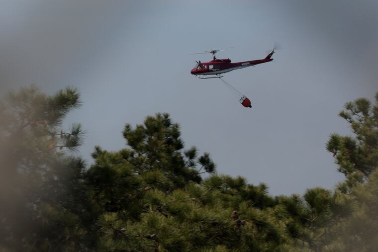 A helicopter, possibly fighting the Jones Road Wildfire, is seen from Wells Mill Road by the Garden State Parkway’s Waretown toll plaza in New Jersey.