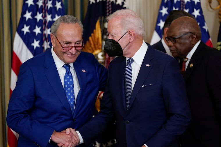 President Joe Biden shakes hands with Senate Majority Leader Chuck Schumer after signing the Inflation Reduction Act on Tuesday.