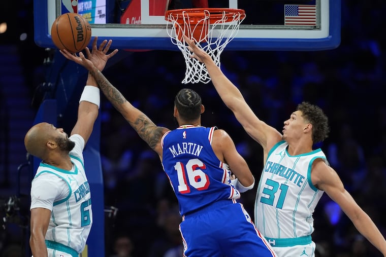 The Sixers' Caleb Martin goes up for a shot between Charlotte's Taj Gibson (left) and Tidjane Salaun during the first half Sunday.