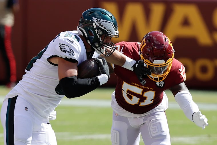 Eagles tight end Dallas Goedert shoves away Washington Football Team linebacker Shaun Dion Hamilton in Sunday's season-opening loss. Goedert caught eight passes for 101 yards and a touchdown, and his continued growth could make it difficult for the Eagles to justify re-signing fellow tight end Zach Ertz.