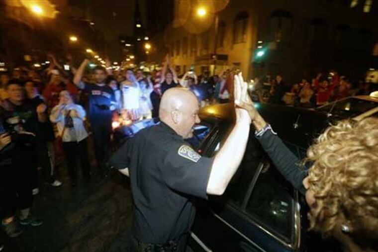A police officer and a woman react to news of the arrest of one of the Boston Marathon bombing suspects, Friday, April 19, 2013, in Boston. Boston Marathon bombing suspect Dzhokhar Tsarnaev was captured in Watertown, Mass. The 19-year-old college student wanted in the bombings was taken into custody Friday evening after a manhunt that left the city virtually paralyzed and his older brother and accomplice dead. (AP Photo/Julio Cortez)