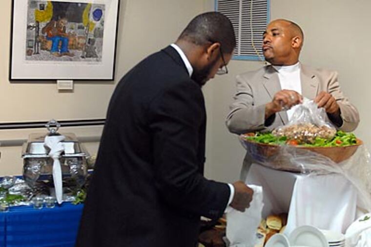David Simms (right) has helped employee Nasim Brown get back on his feet after a stint in prison derailed his college education. (Tom Gralish/Staff Photographer)