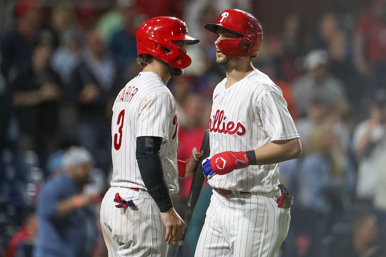 Trea Turner passes teammate Bryce Harper after Turner’s home run in a game against the Boston Red Sox.