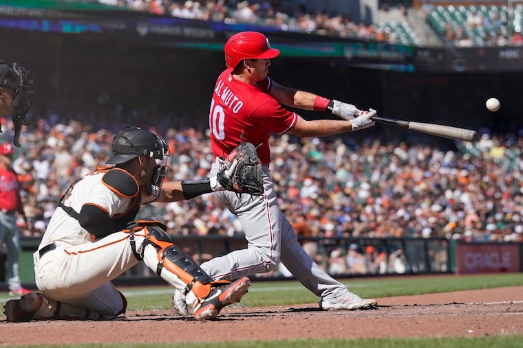Philadelphia Phillies' J.T. Realmuto, right, hits a three-run home run in front of San Francisco Giants catcher Austin Wynns during the eighth inning of a baseball game in San Francisco, Sunday, Sept. 4, 2022. (AP Photo/Jeff Chiu)