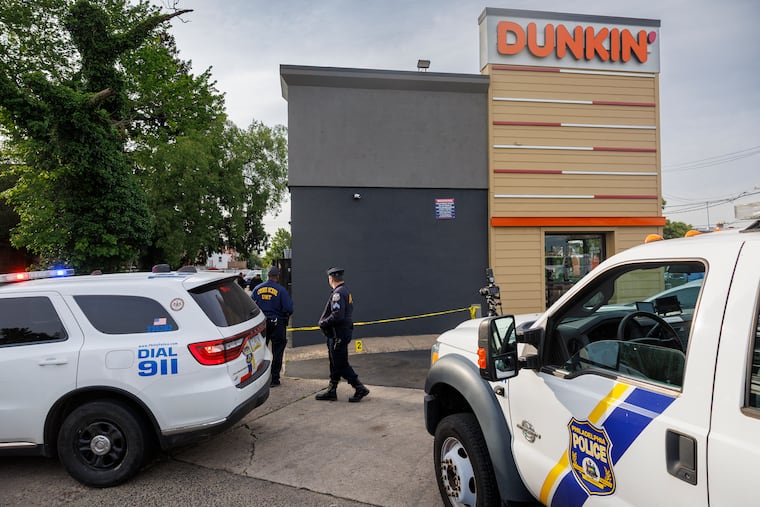 Philadelphia Police Crime Scene Unit officers outside the Dunkin Donuts on Roosevelt Boulevard at Levick Street after Tuesday's shooting.