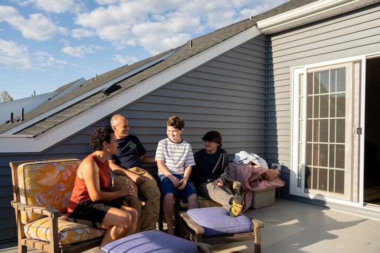 Patty and Joe Salinas, and two of their children, Nick, 11, (left) and Ben, 15, sit on the fourth-floor deck of their Phoenixville townhouse.