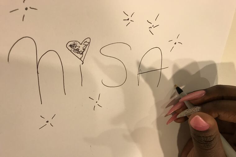 Newsroom security attendant Inisa Thomas-Young writes (and doodles) her nickname.