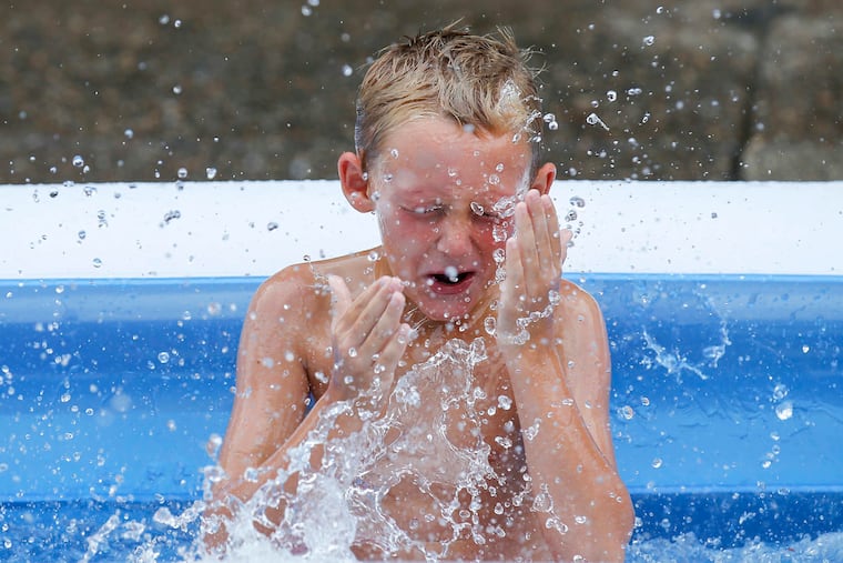 Dominic Denaro, 8, cools off in a inflatable pool on the 2500 block of Darien Street in South Philadelphia.