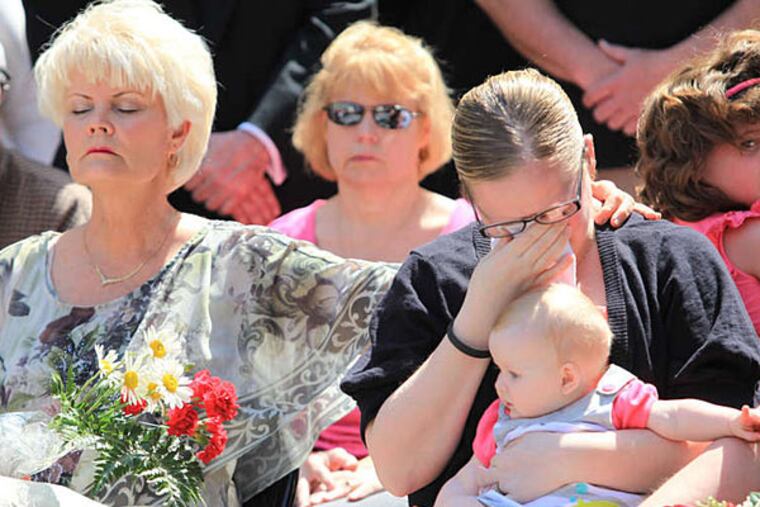 Diane Neary, the widow of Lt. Robert Neary, comforts Capt. Michael Goodwin's daughter, Dorothy (right), on Tuesday at a ceremony honoring the fallen firefighters. (Jad Sleiman/Daily News Staff)