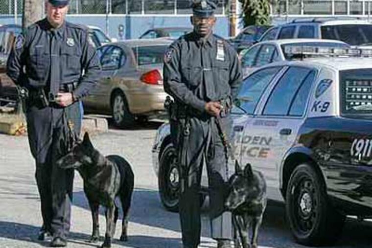 File photo: Camden Police officers, Carl Godlewski (left) with his dog Deezl and Zsakhiem James with hs dog Zero pose in 2008 for a photo. (Akira Suwa / Staff Photographer)
