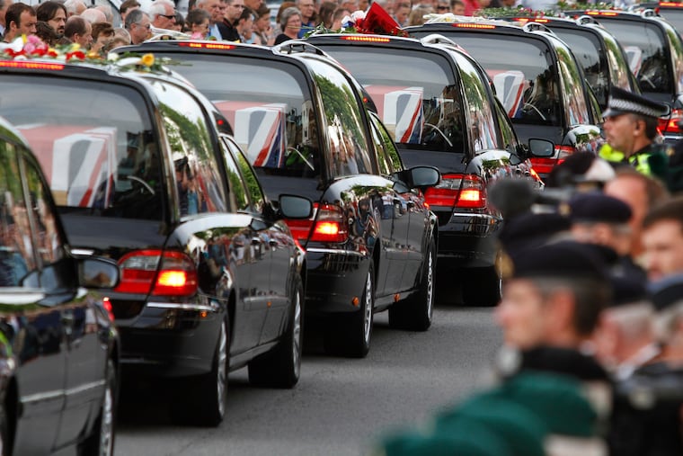 The coffins of seven British soldiers killed in Afghanistan, are driven through the town of Wootton Bassett, England, after repatriation to Britain, Tuesday, June 29, 2010.