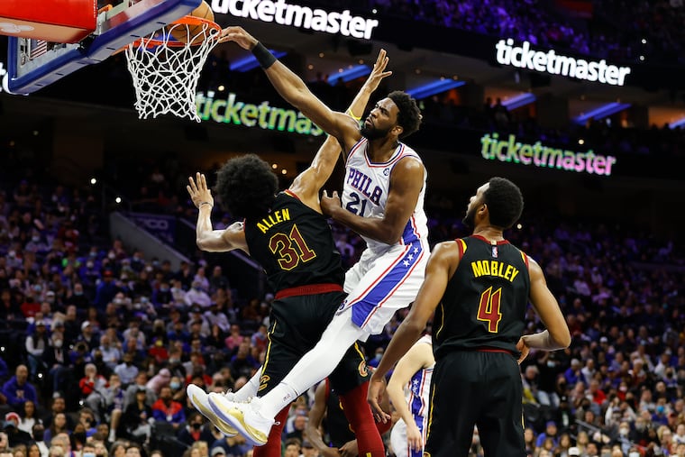 Sixers center Joel Embiid dunks the basketball over Cleveland Cavaliers center Jarrett Allen and forward Evan Mobley in the second quarter on Saturday, February 12, 2022 in Philadelphia.