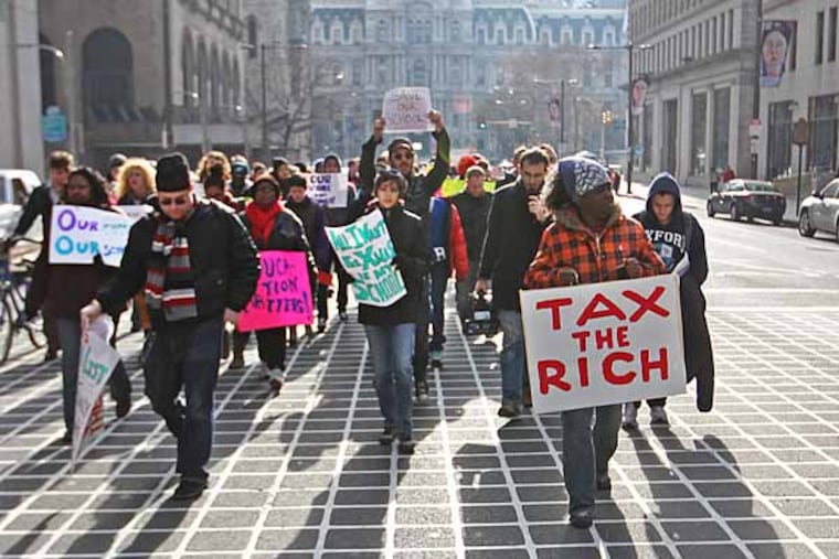 Marchers protesting the 37 school closings by the Philadelphia School District cast long shadows down Broad Street as they marched from around City Hall to 440 N. Broad Street, the district's headquarters. ( MICHAEL BRYANT / Staff Photographer )