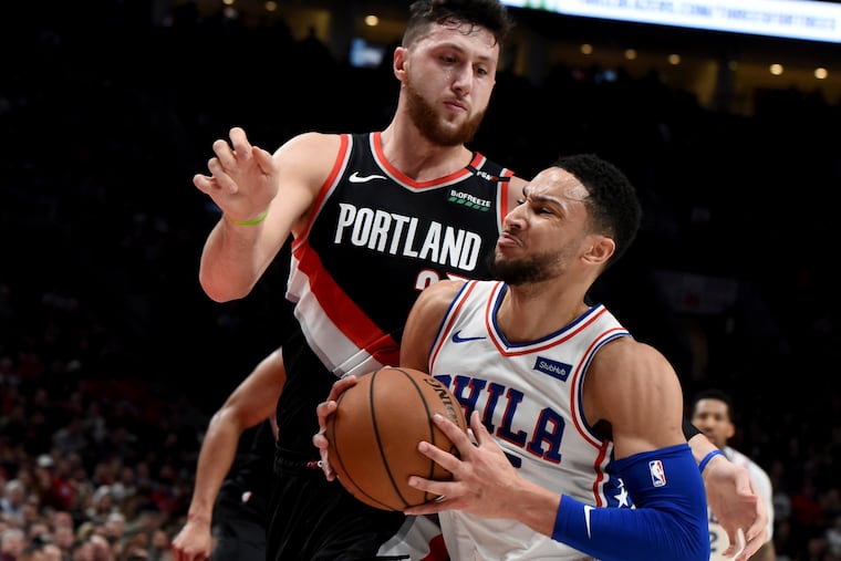 Sixers guard Ben Simmons (right) drives to the hoop on Portland's Jusuf Nurkic.