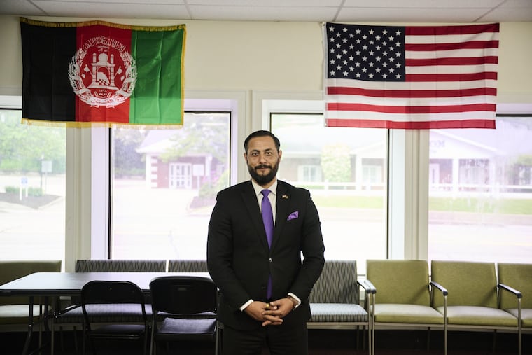 Saeed Taraky, the city of Erie’s immigrant and refugee liaison, stands in front of Afghan and American flags at the Afghan Community Center in Erie, Pa.