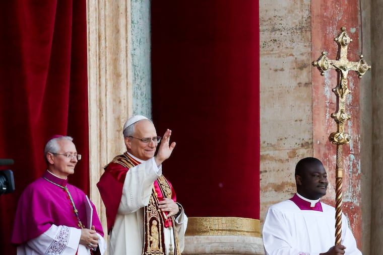 Pope Leo XIV, center, appears on the balcony of St. Peter’s Basilica after becoming the first American pope.