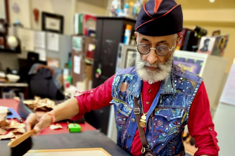 Richard Watson, an artist in residence and exhibits manager with the African American Museum in Philadelphia, prepares one of Dox Thrash's works for the new exhibit.
